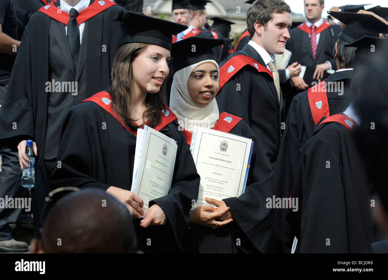 GRADUATES PROUDLY POSE WITH THEIR DEGREES AS THEY  CELEBRATE THEIR GRADUATION DAY AT A BRITISH UNIVERSITY Stock Photo