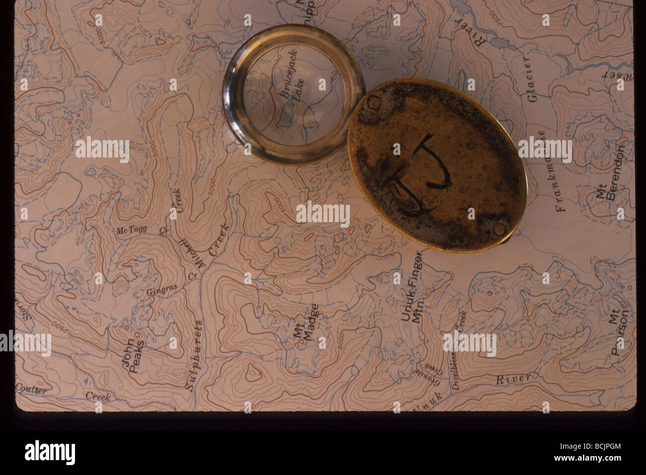 Magnifying lupe on topographical map Stock Photo