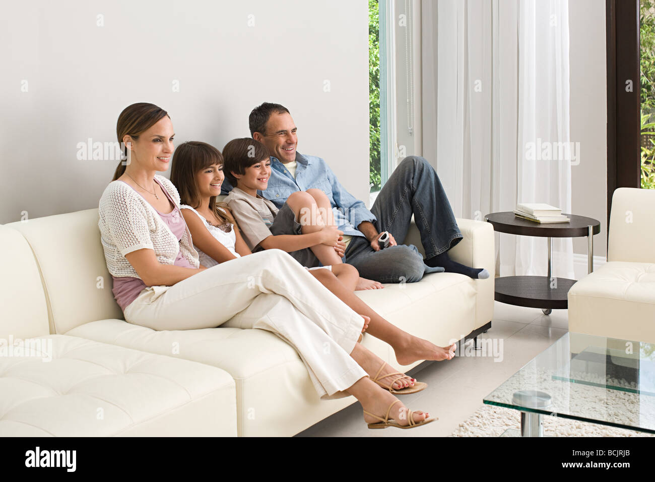 Family relaxing on a sofa Stock Photo Alamy
