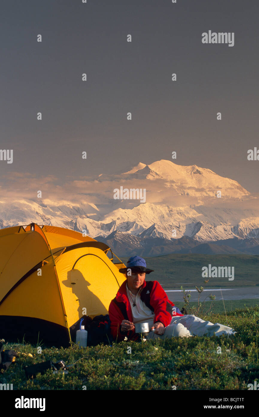 Backpacker by Tent w/Mt McKinley Denali NP IN AK Summer Stock Photo