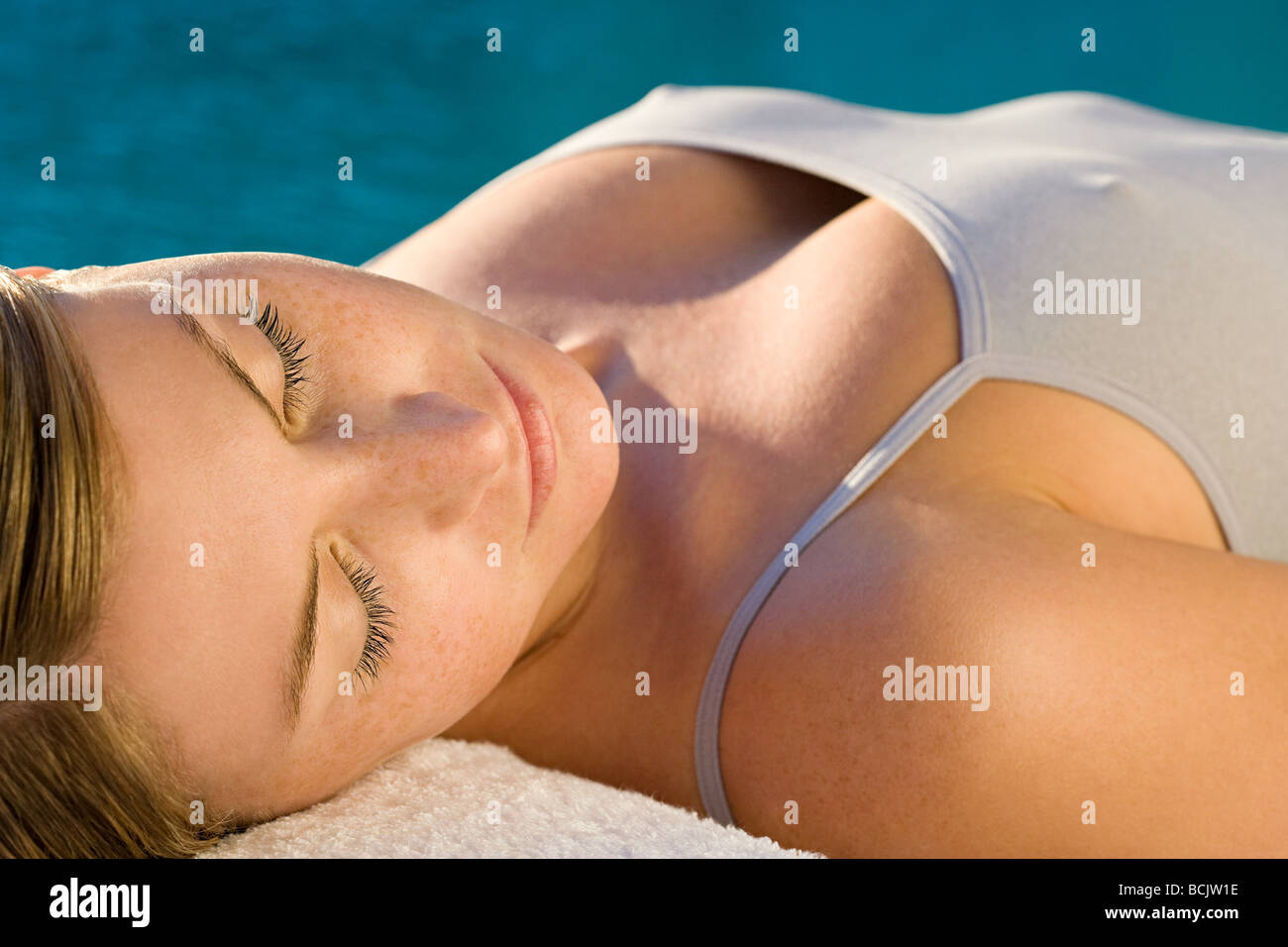 Young woman lying on massage table by the pool Stock Photo