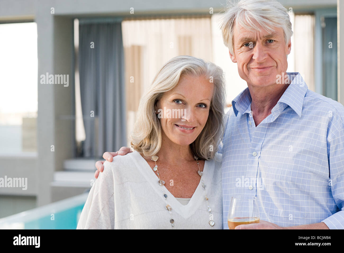 Middle aged couple standing outside house Stock Photo - Alamy