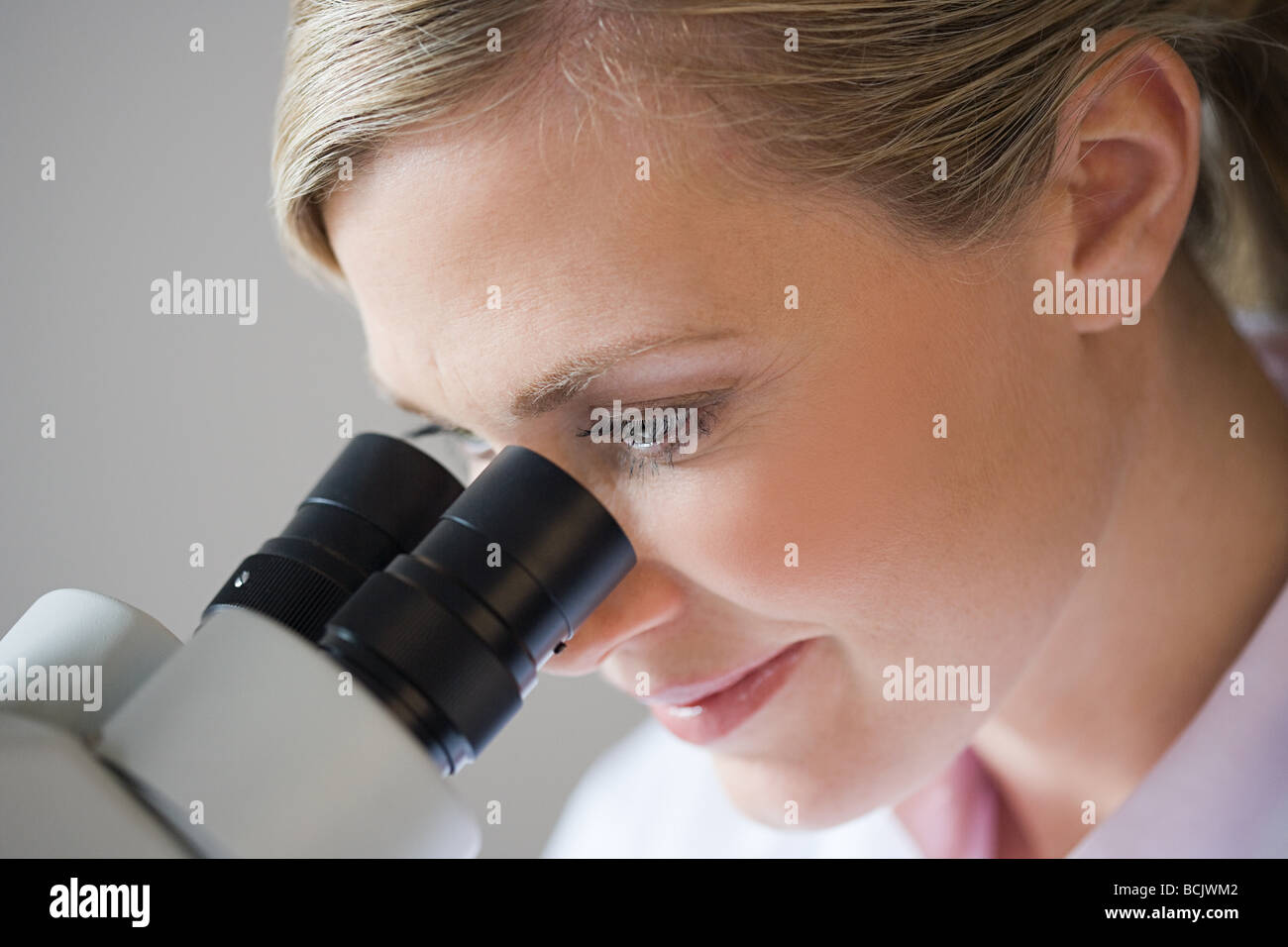 Female scientist using a microscope Stock Photo