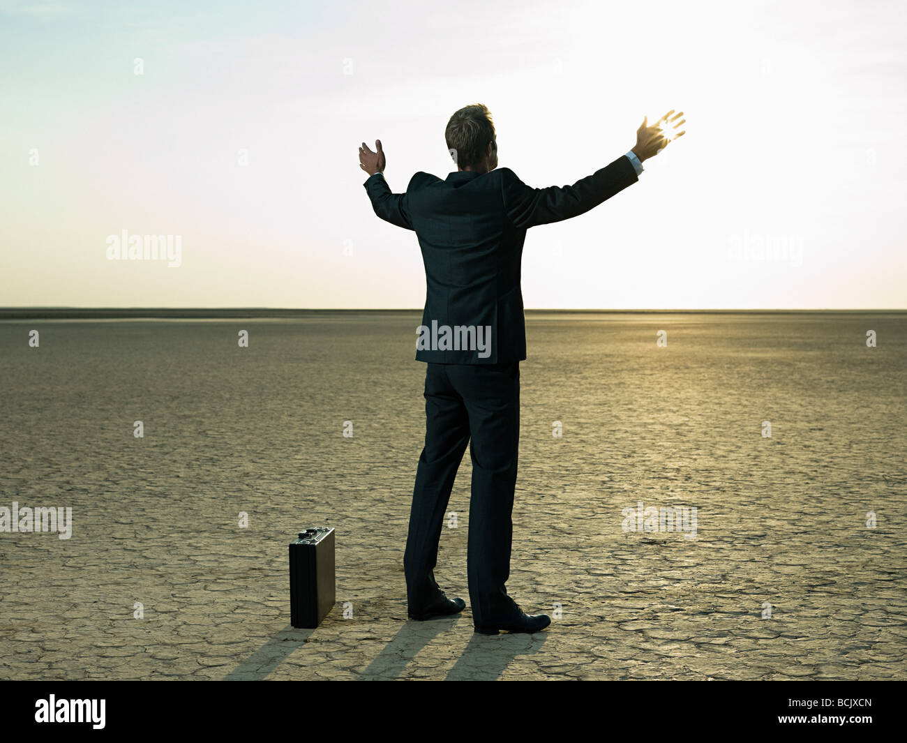 Businessman raising his arms in a desert Stock Photo - Alamy