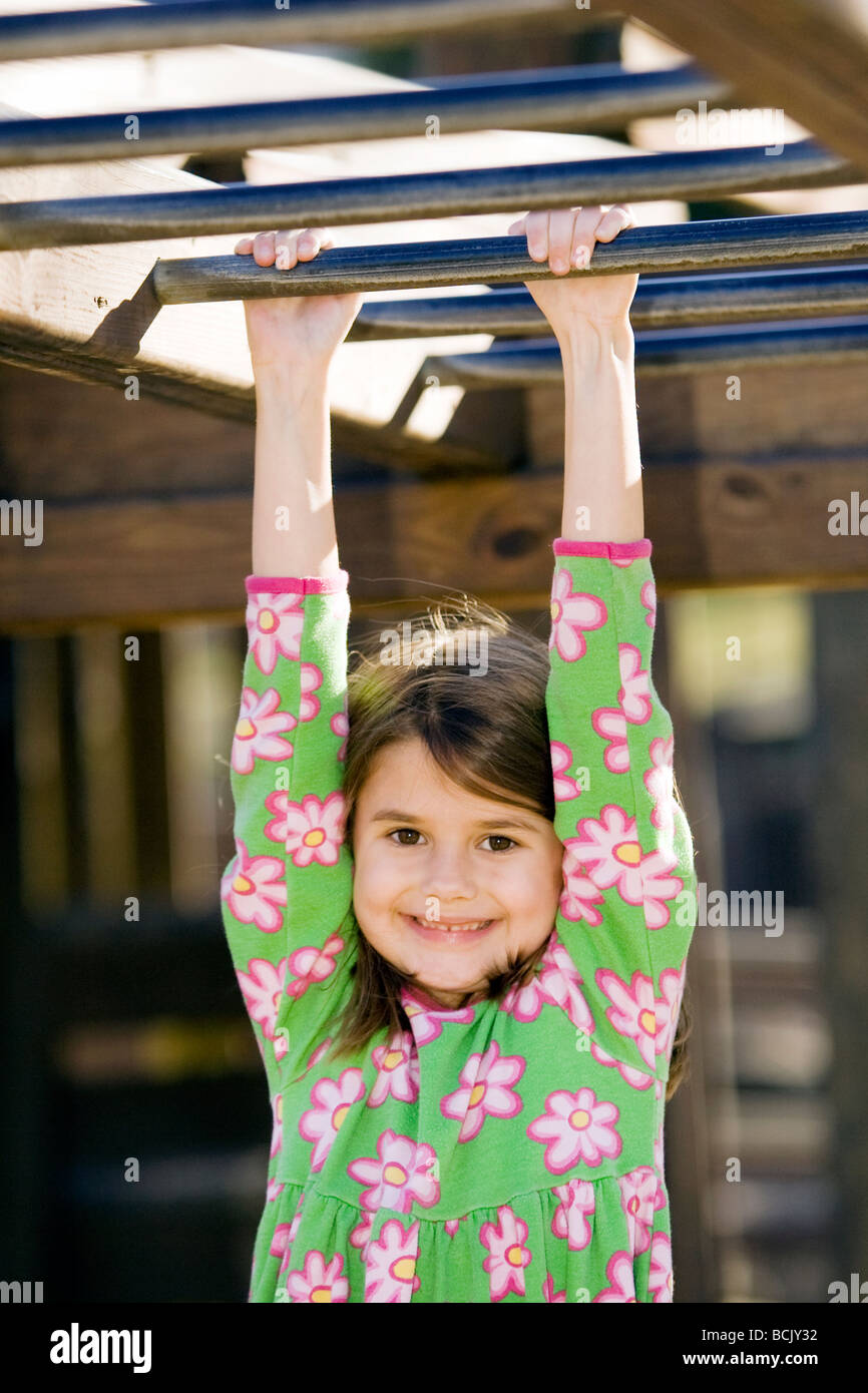 Young girl hanging on monkey bars at playground - Franklin Park - Brevard, North Carolina Stock Photo