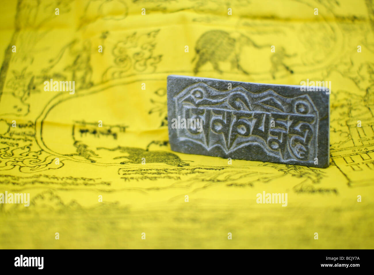 The most popular Tibetan mantra "Om Mani Padme Hum" carved on a little stone plate. Stock Photo