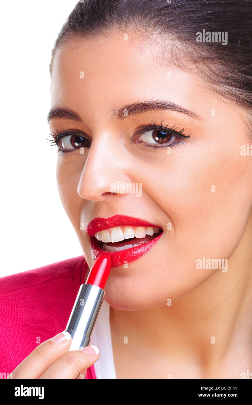 A brunette woman applying red lipstick Stock Photo