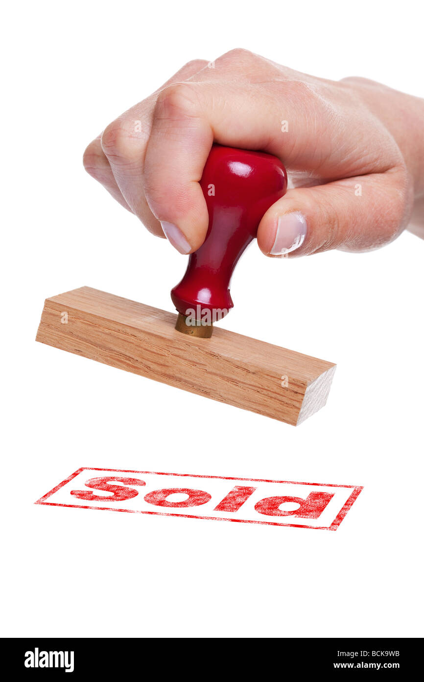 Hand holding a rubber stamp with the word Sold Stock Photo