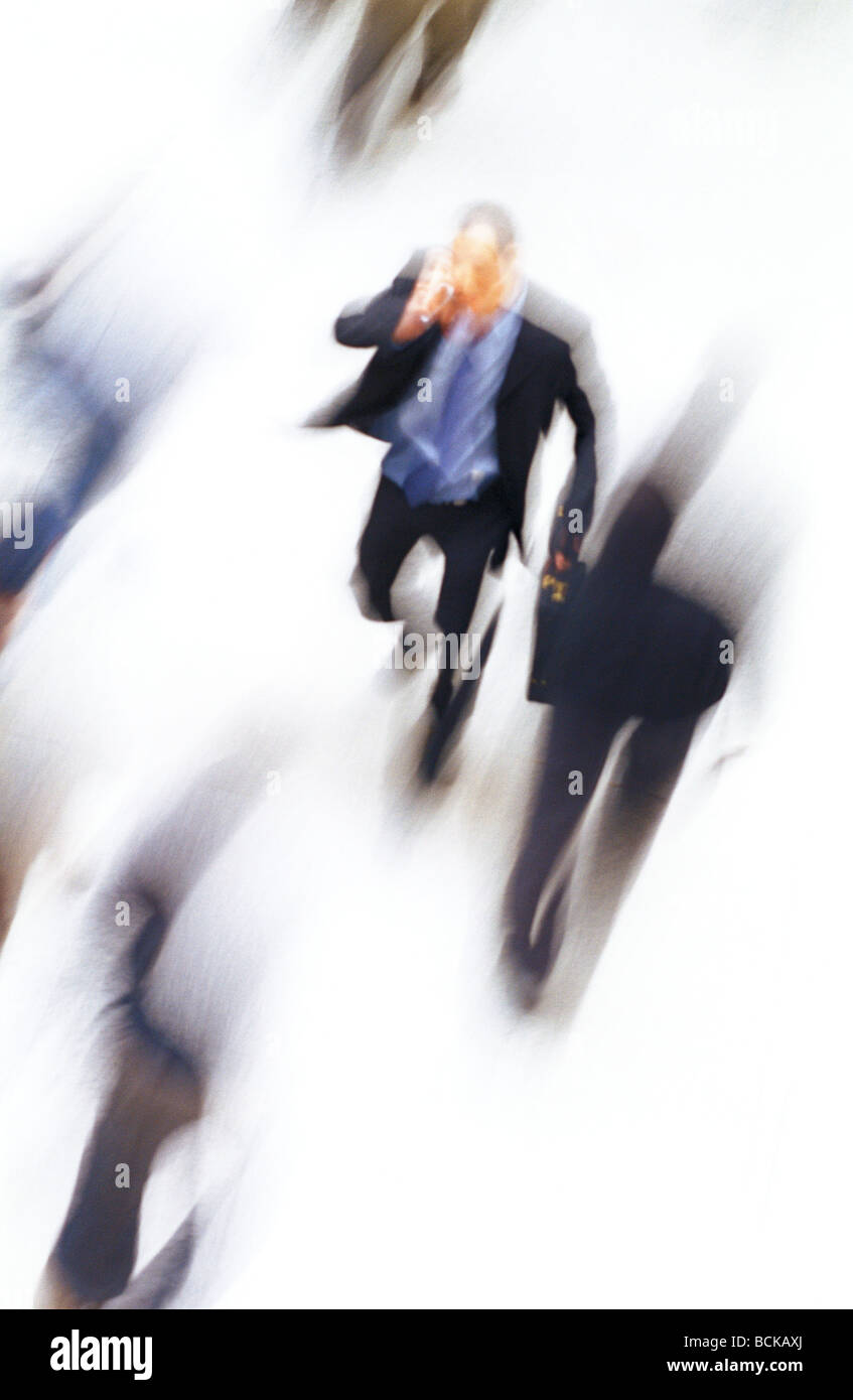 Businessman walking, talking on cell phone, high angle view, blurred Stock Photo