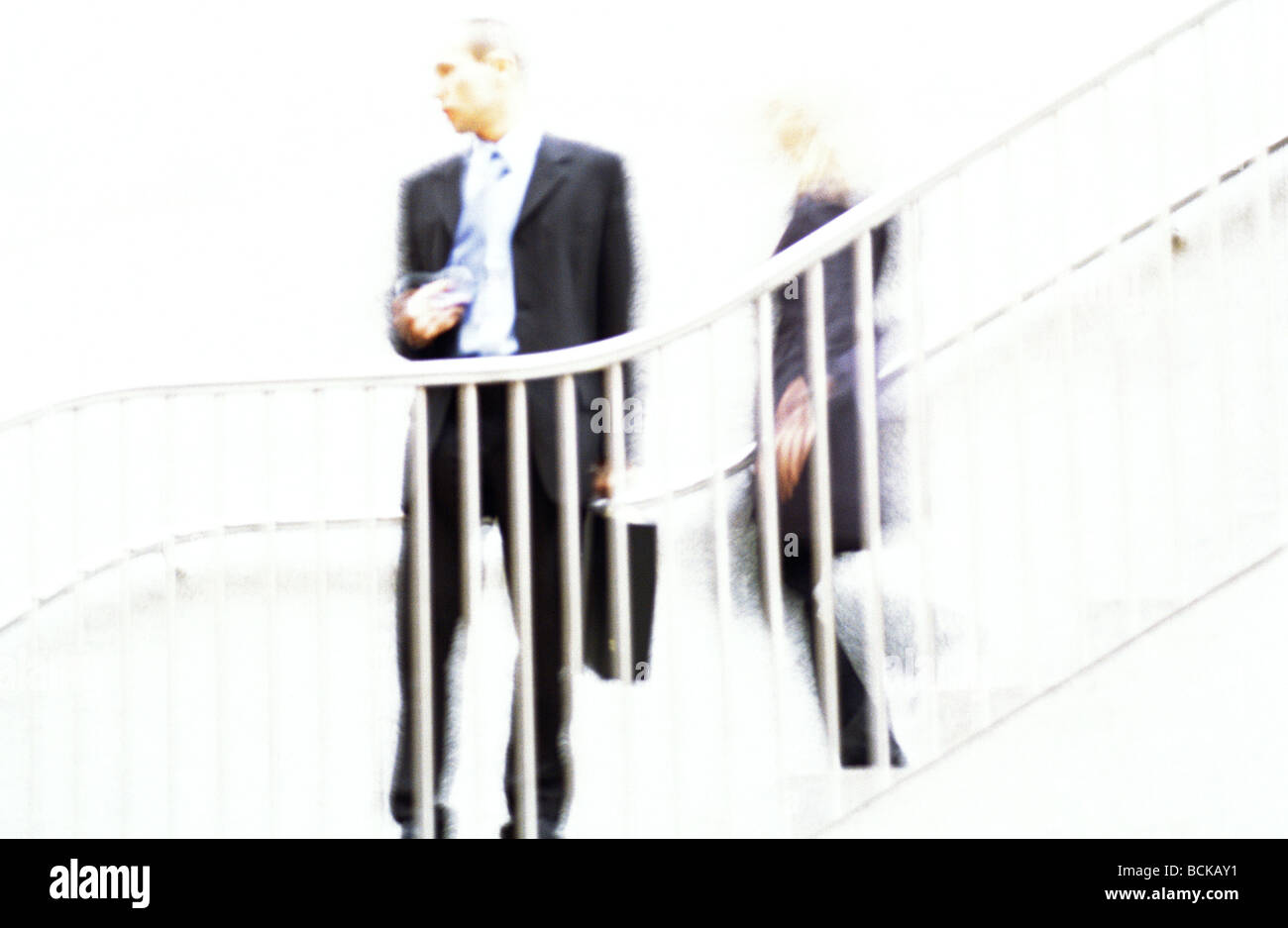 Businessman standing behind guard rail, blurred Stock Photo
