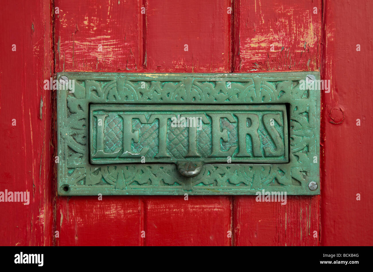 Brass letters box on red wooden door in village of Kingsand, Cornwall, UK Stock Photo