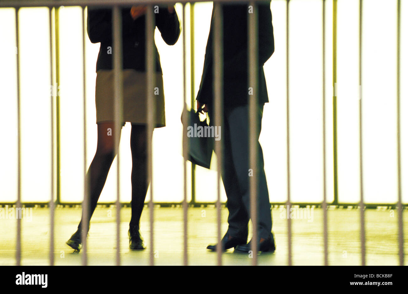 Man and woman standing behind railings, lower section Stock Photo - Alamy