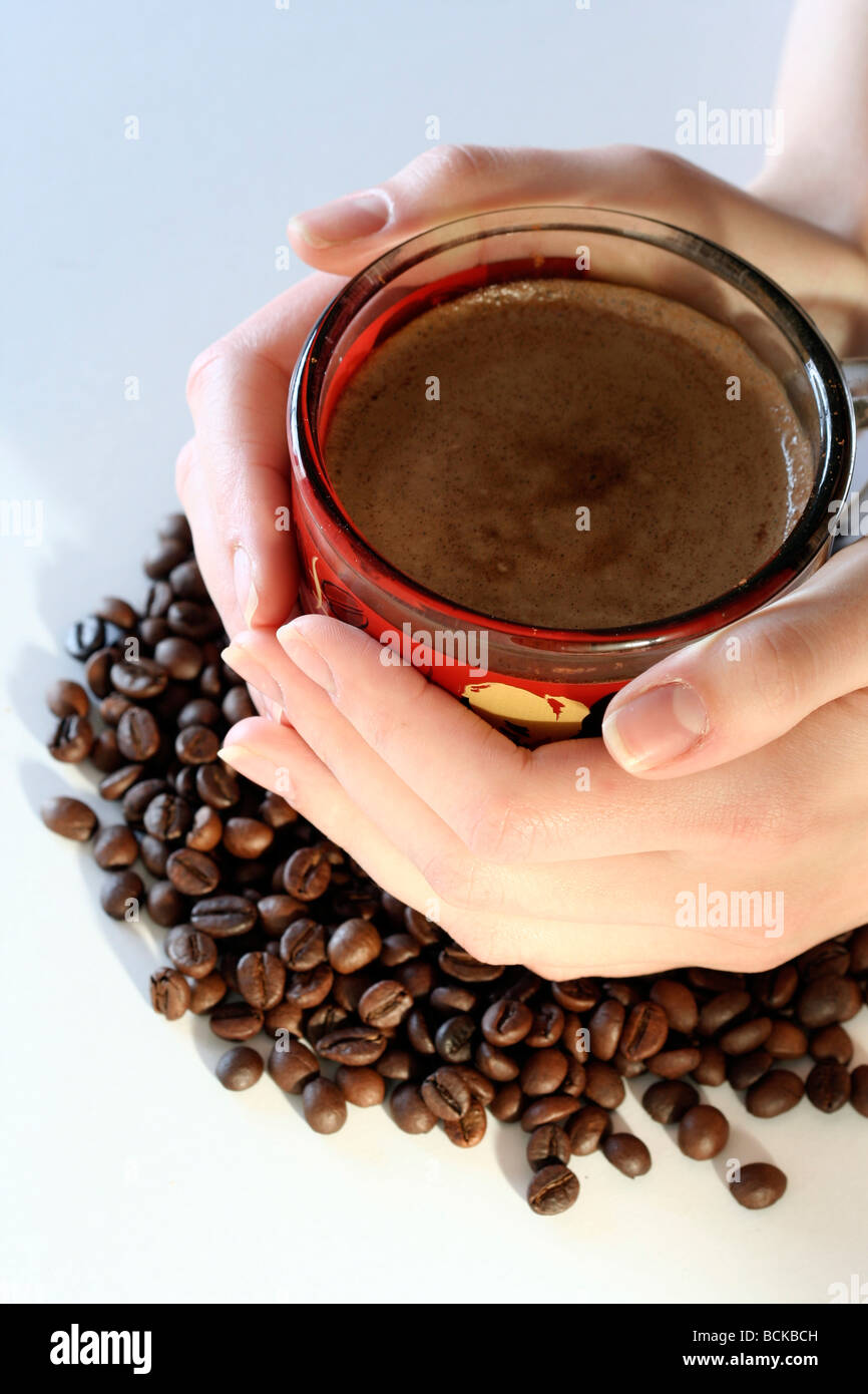 Cup with coffee, costing on coffee grain. Stock Photo