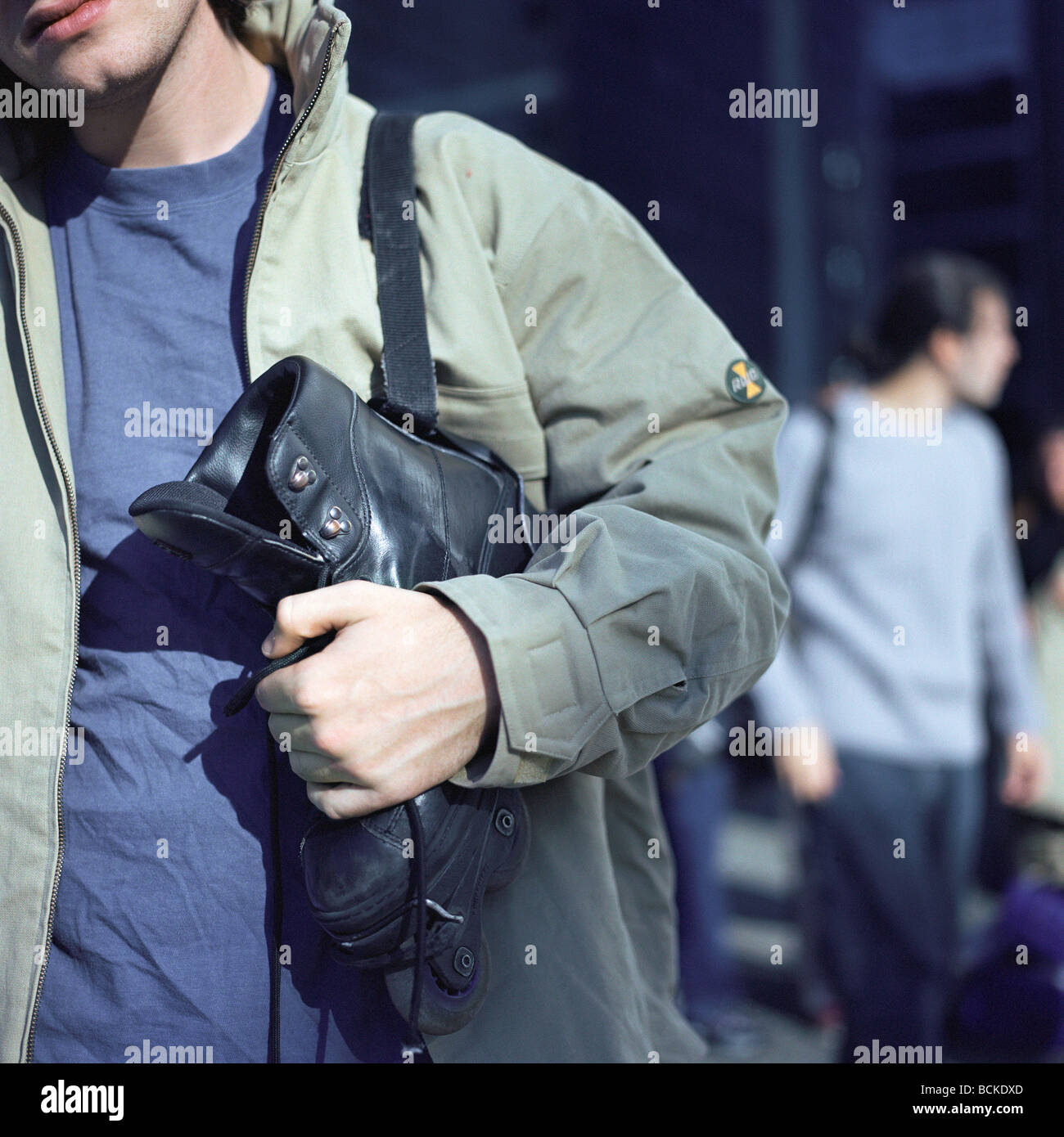 Urban scene, young man holding in-line skate Stock Photo