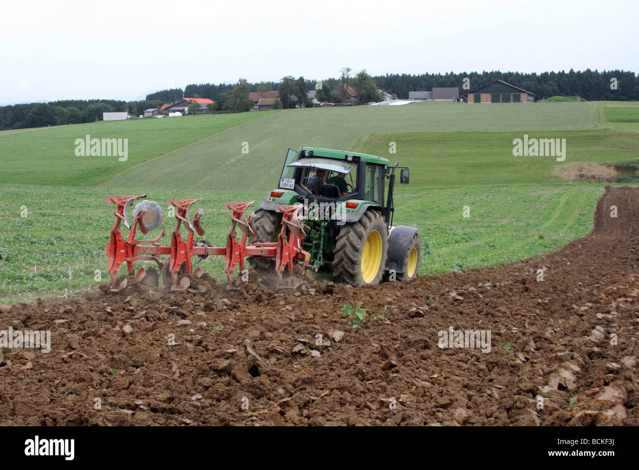 Farmer plowing with his tractor on a field Stock Photo