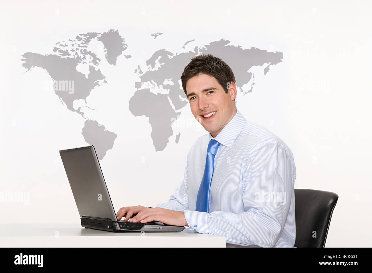 Office worker with laptop and world map Stock Photo