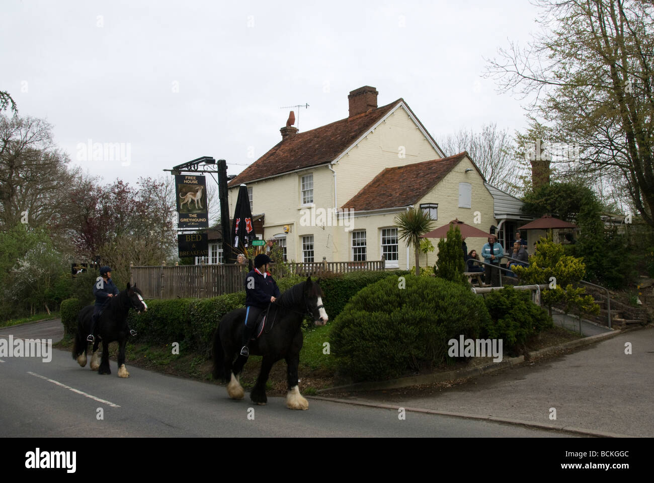 People on horses passing county pub, The Greyhound, Hever Castle village, Kent, England, UK Stock Photo