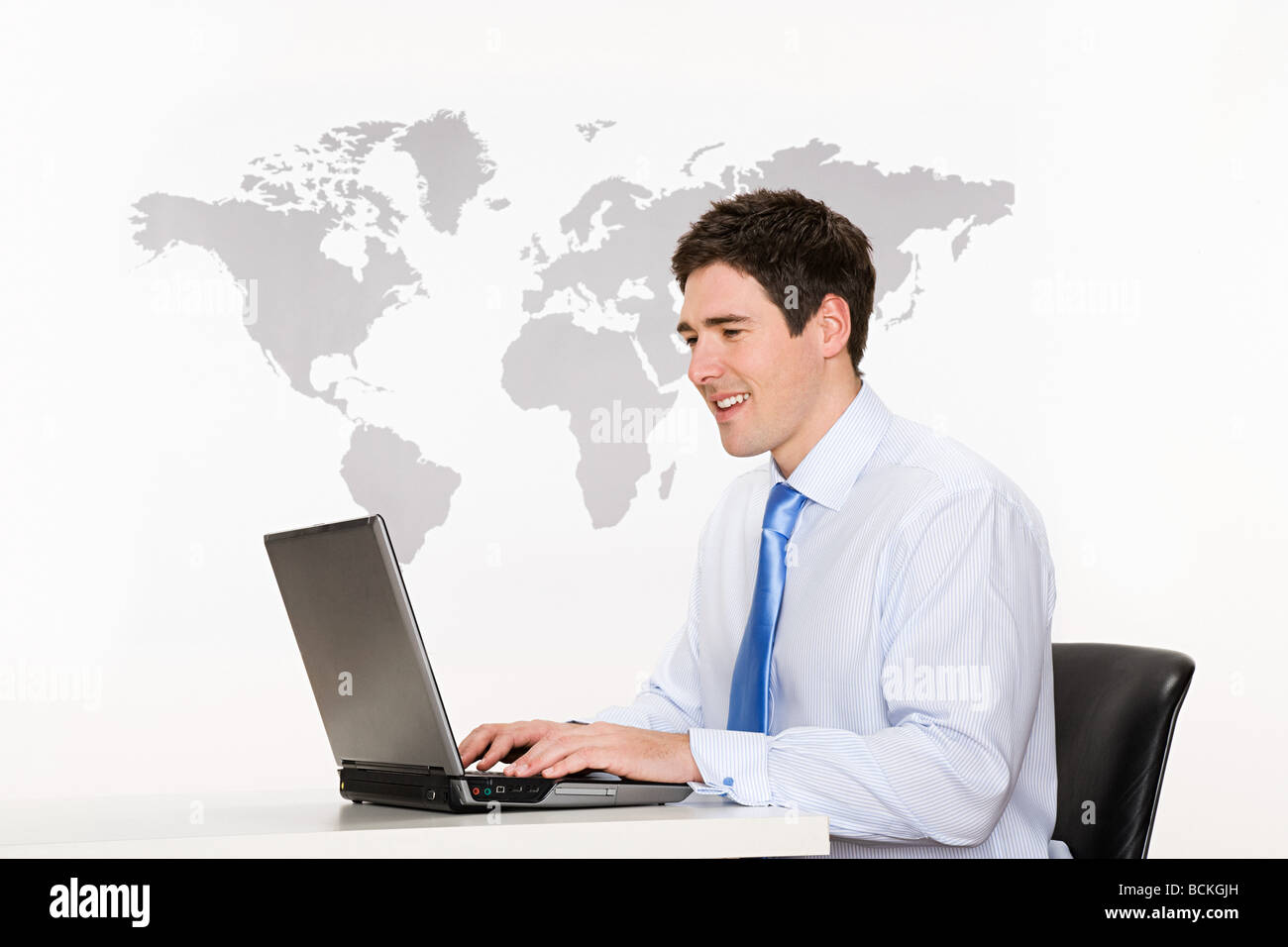 Office worker with laptop and world map Stock Photo