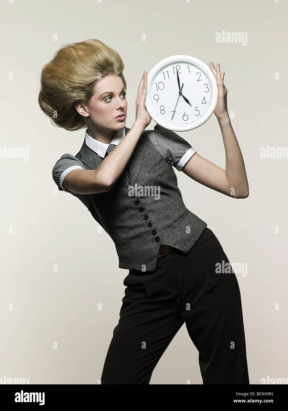 Businesswoman holding clock Stock Photo