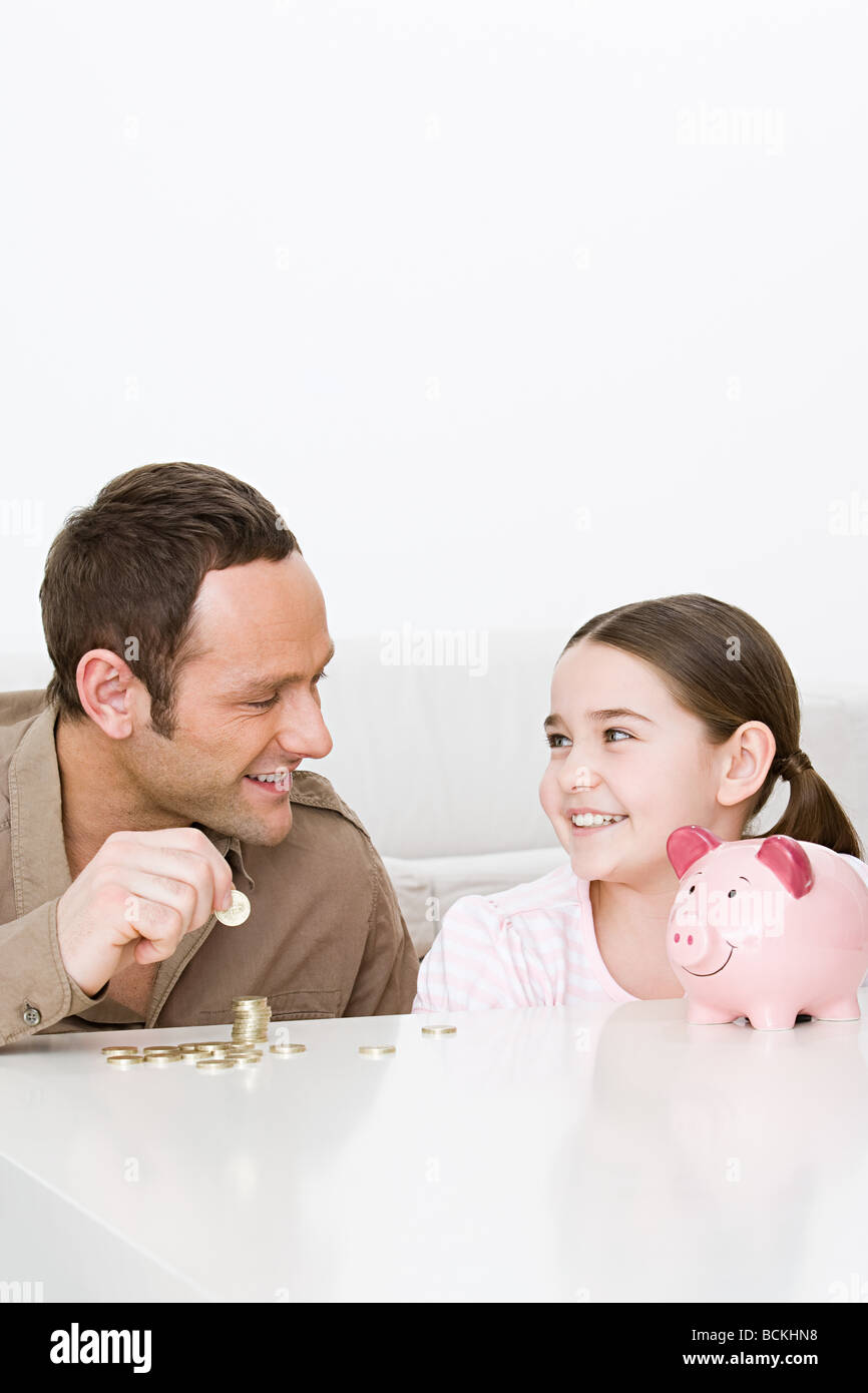Father and daughter with piggy bank Stock Photo - Alamy