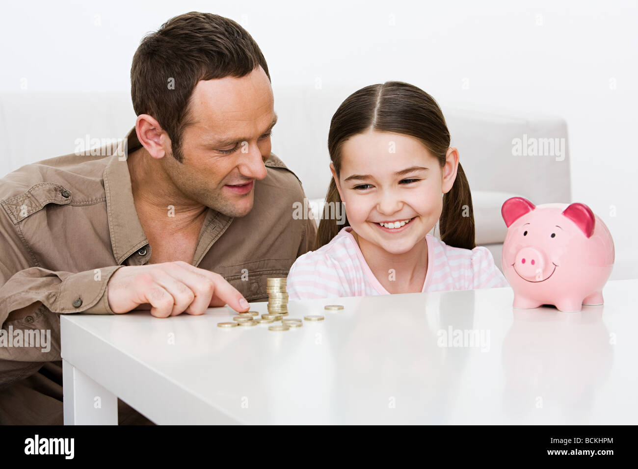 Father and daughter with piggy bank Stock Photo - Alamy