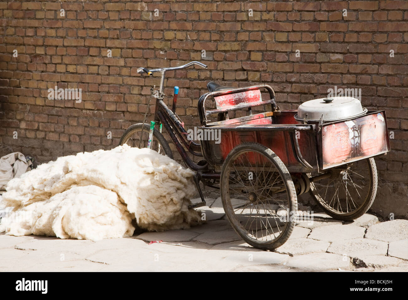 Bicycle next to pile of wool on footpath Stock Photo