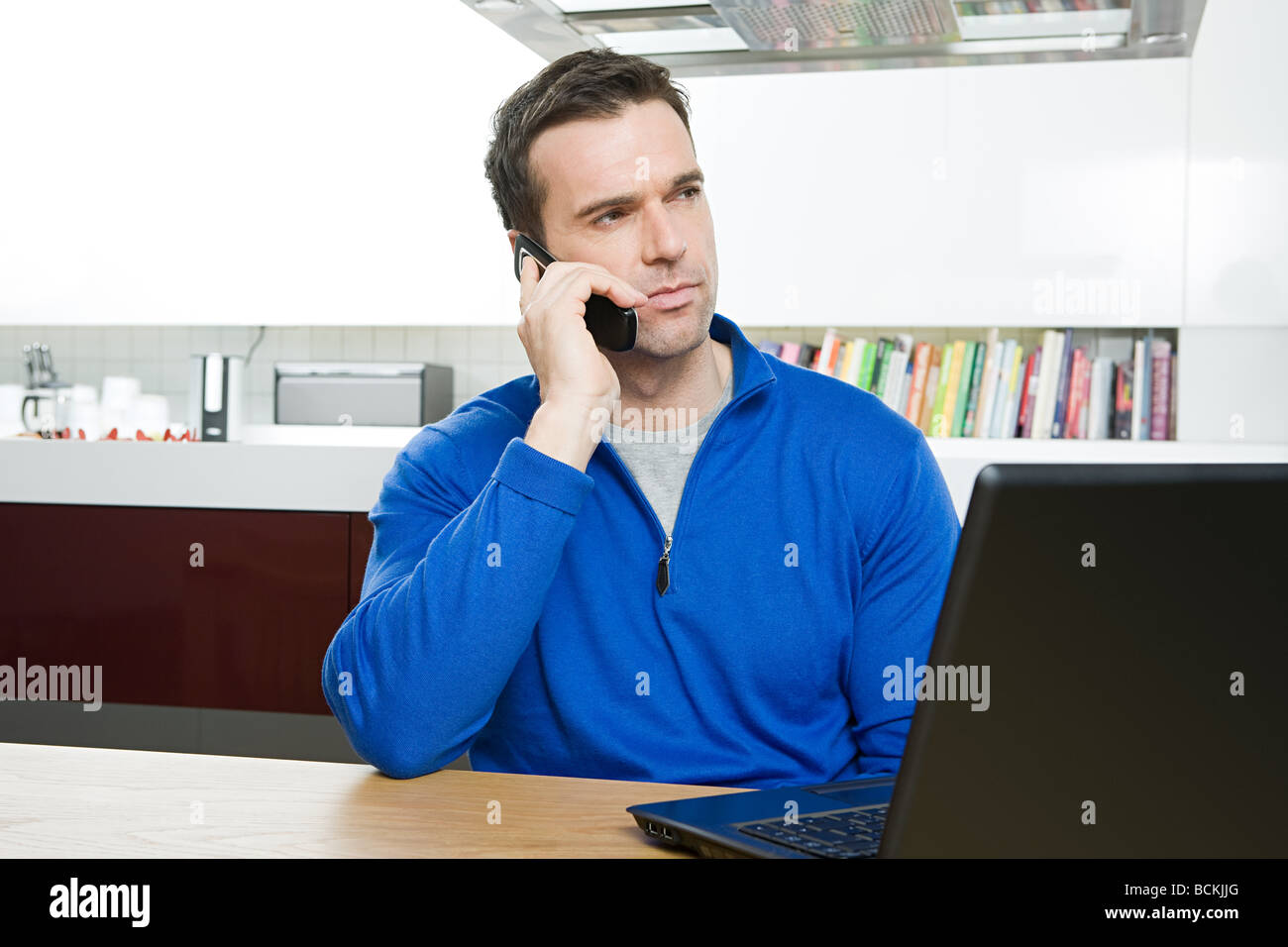 Man with cellphone and laptop Stock Photo - Alamy