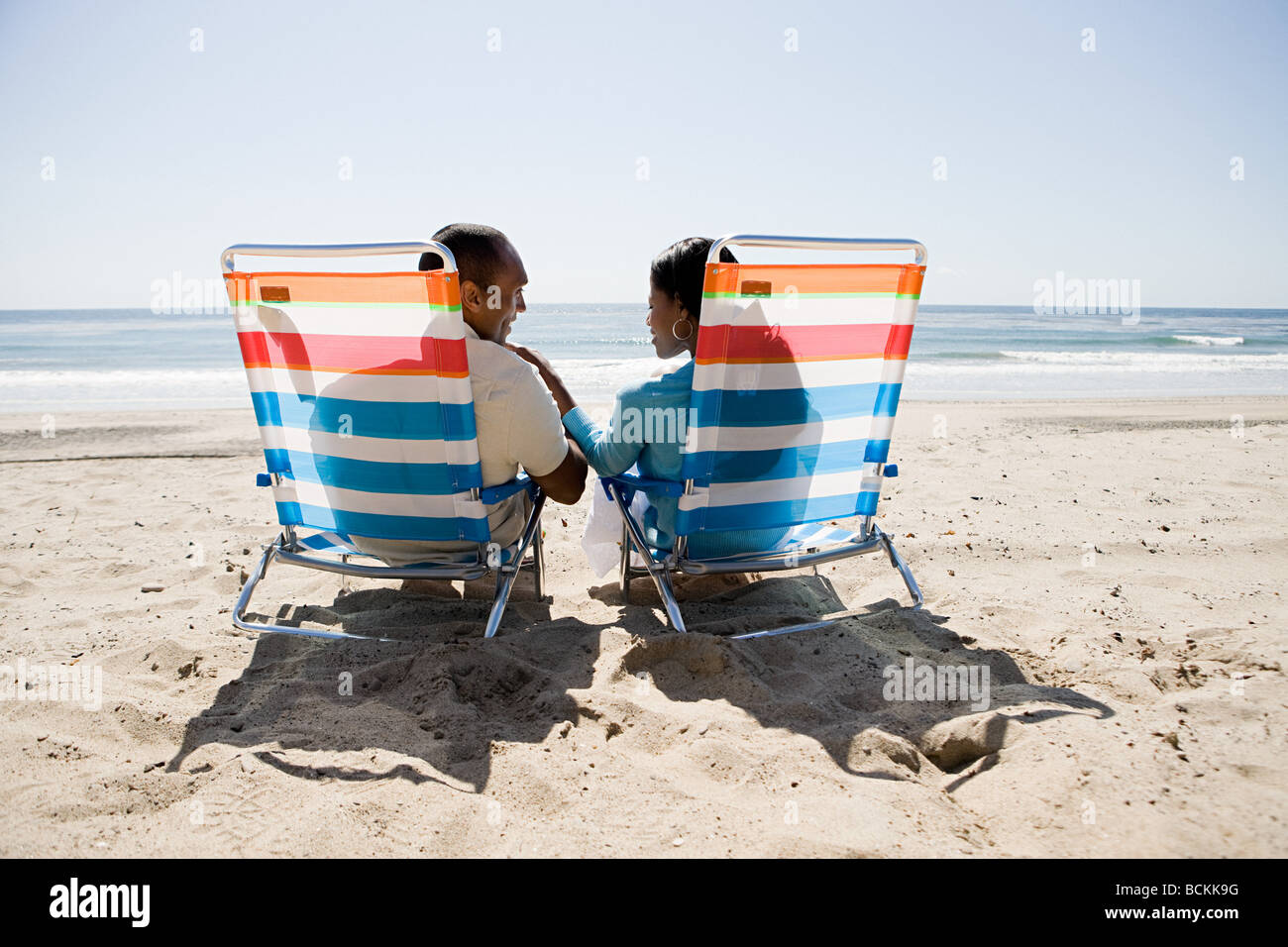 Couple relaxing on a beach Stock Photo - Alamy