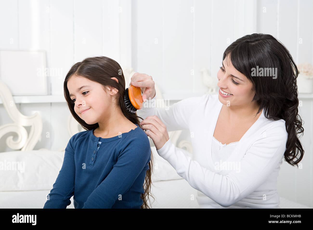 Mother combing daughters hair Stock Photo