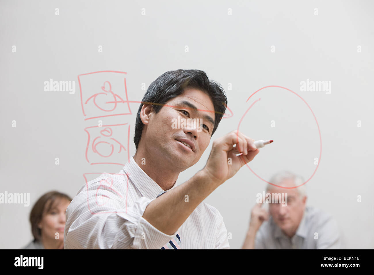 Man drawing diagram on glass wall Stock Photo