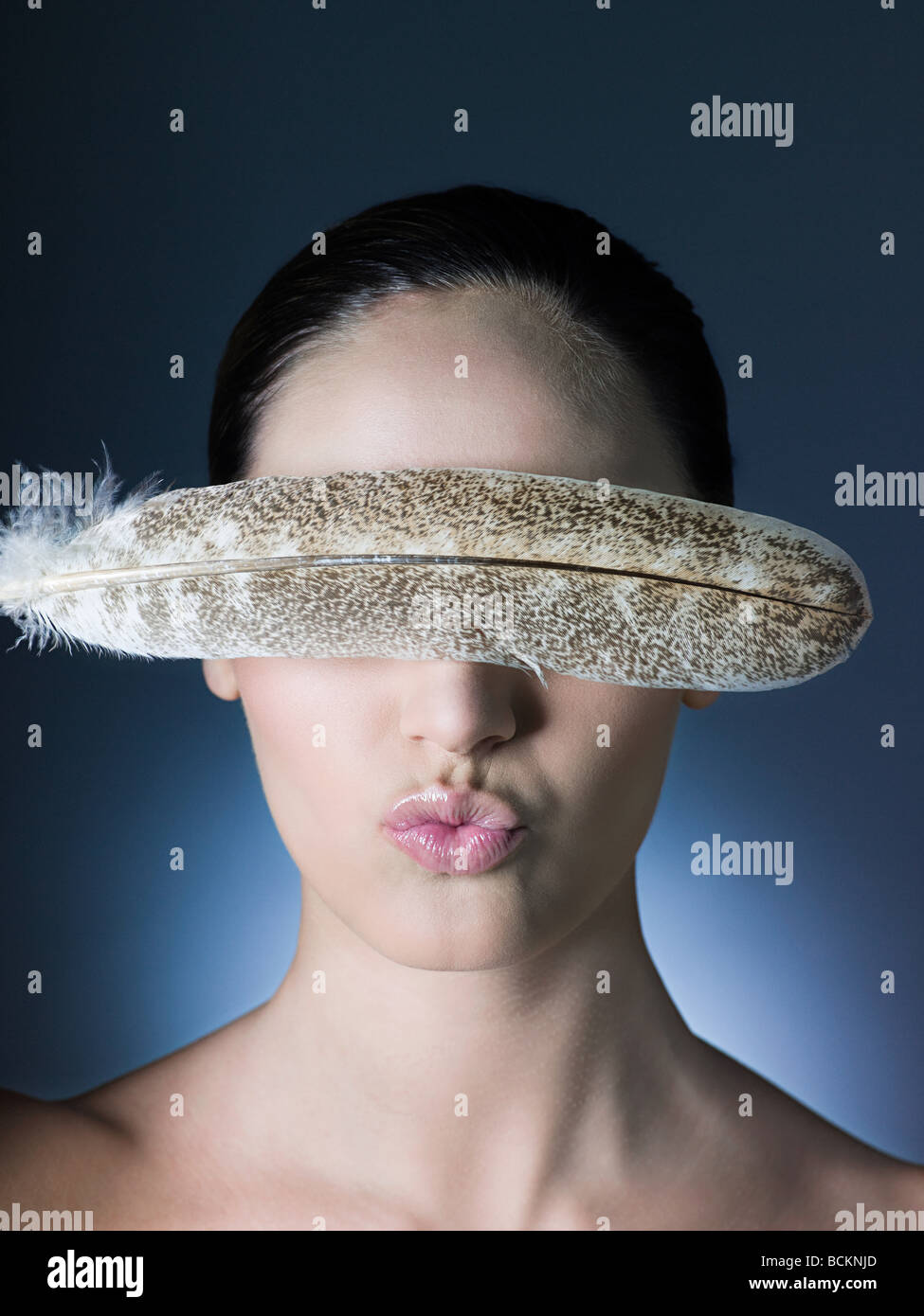 Woman with feather over eyes Stock Photo