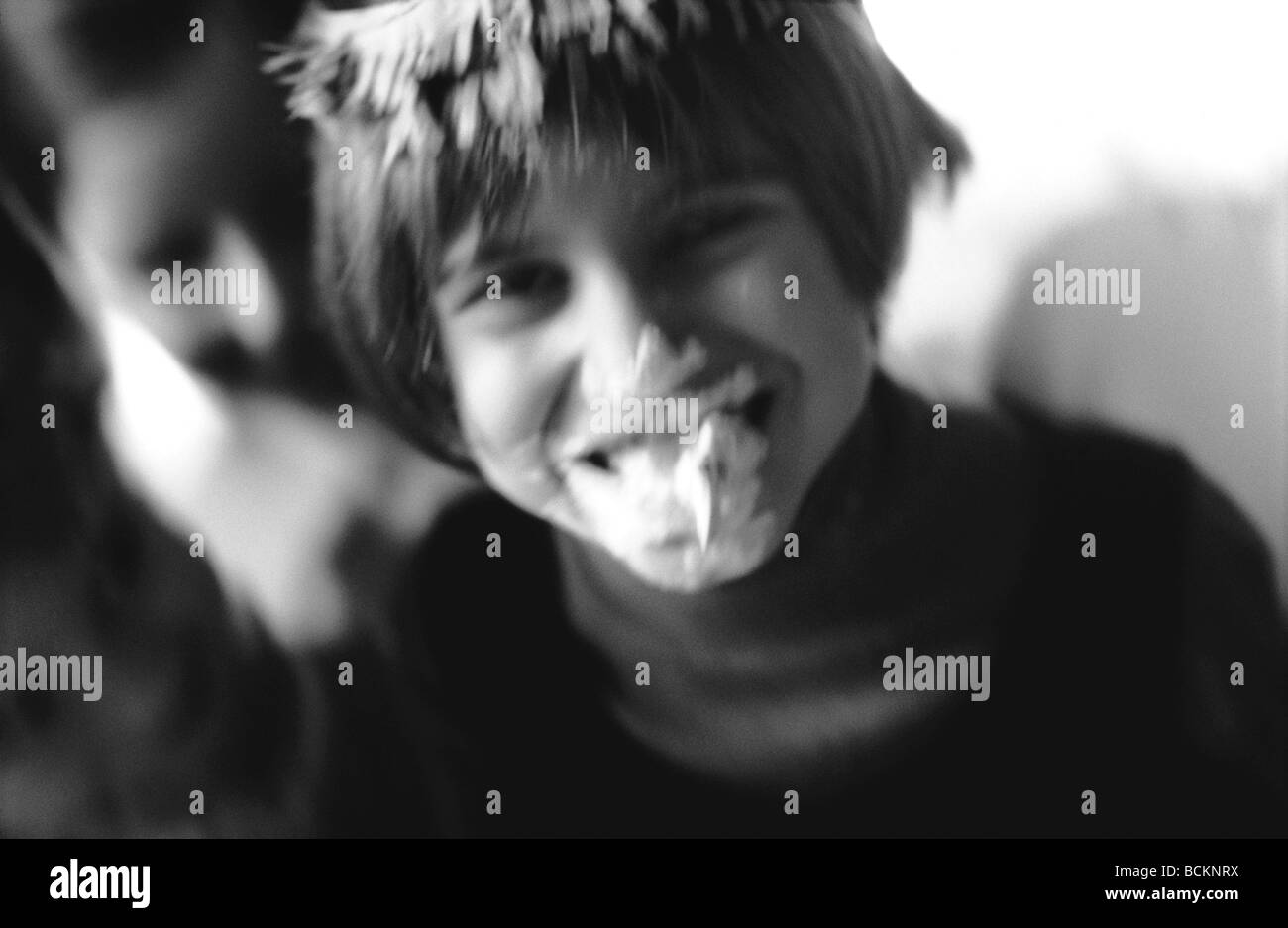 Child laughing with whipped cream on face, b&w Stock Photo