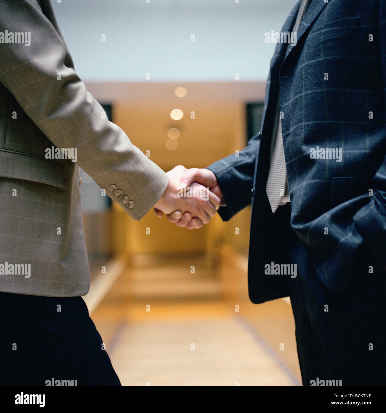 Businessmen shaking hands, mid-section Stock Photo
