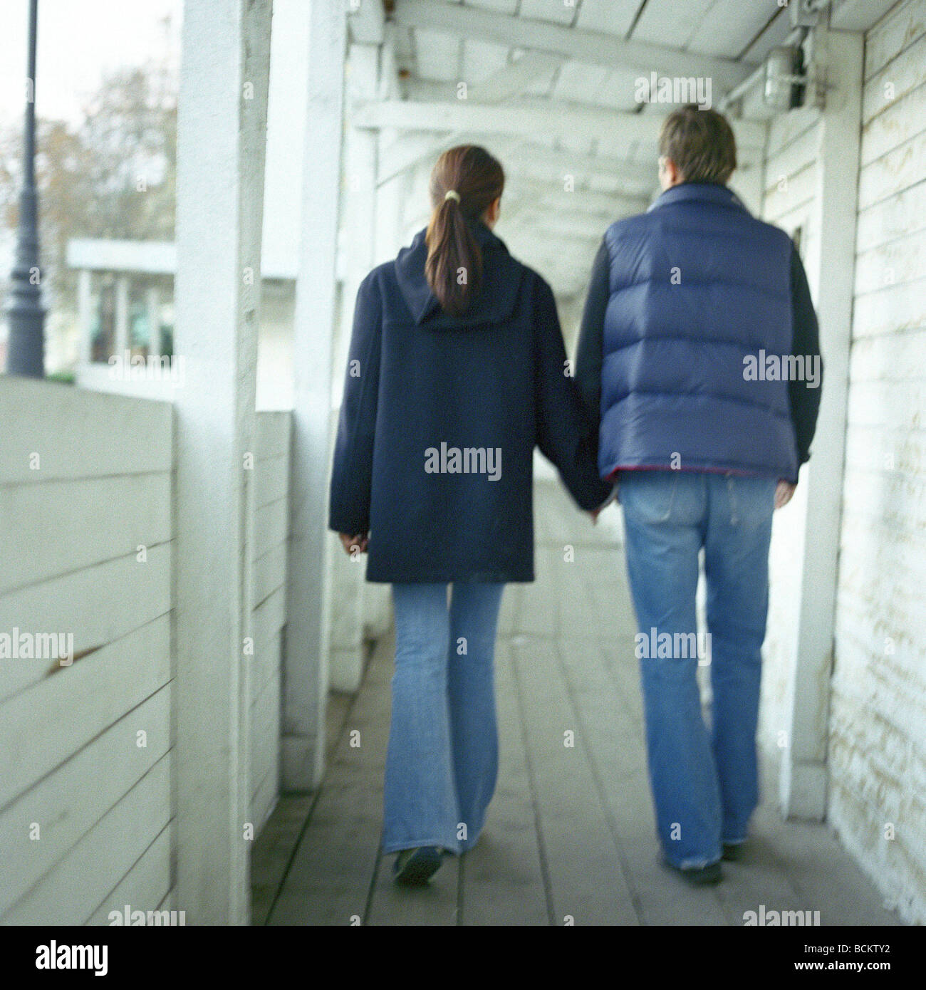 Man and woman walking together in covered walkway Stock Photo - Alamy