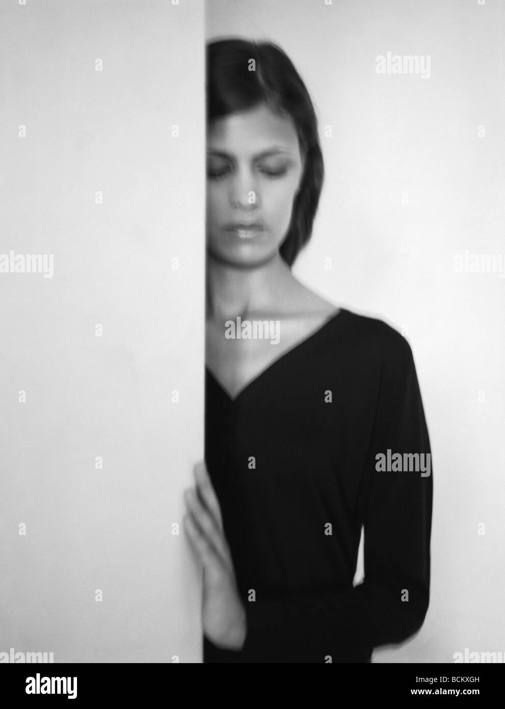 Woman hiding behind wall Black and White Stock Photos & Images - Alamy