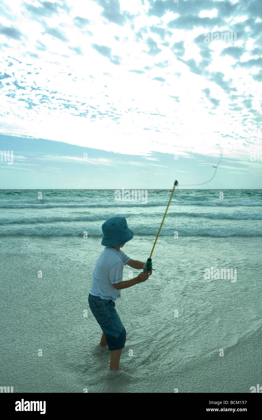 Boy throwing out fishing line on beach, rear view Stock Photo Alamy