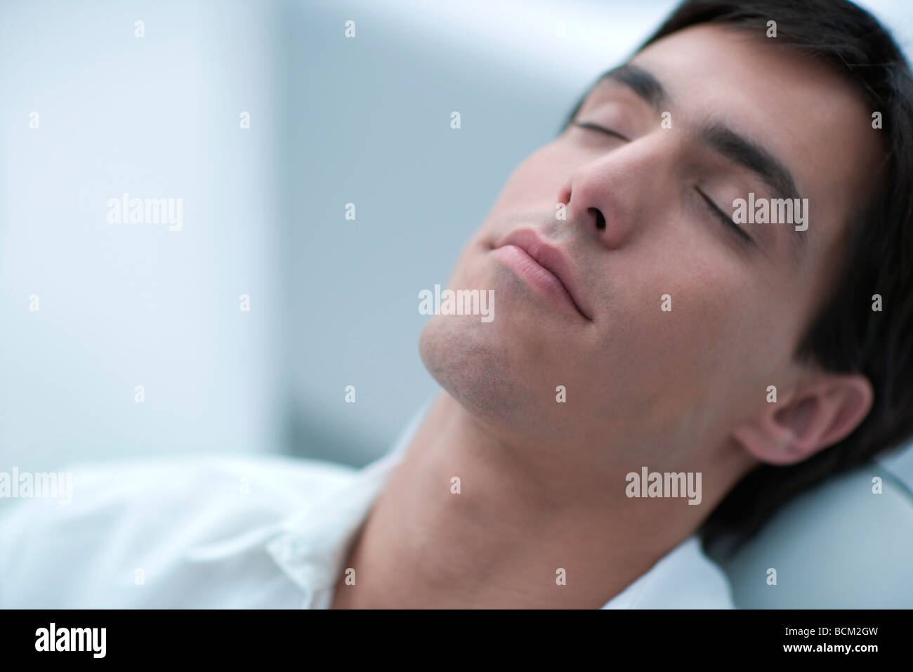 Young man leaning back, eyes closed, close-up Stock Photo - Alamy