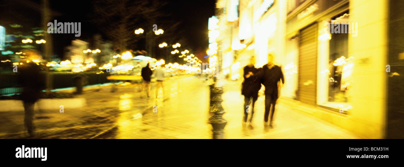 France, Paris, pedestrians walking on sidewalk at night Stock Photo