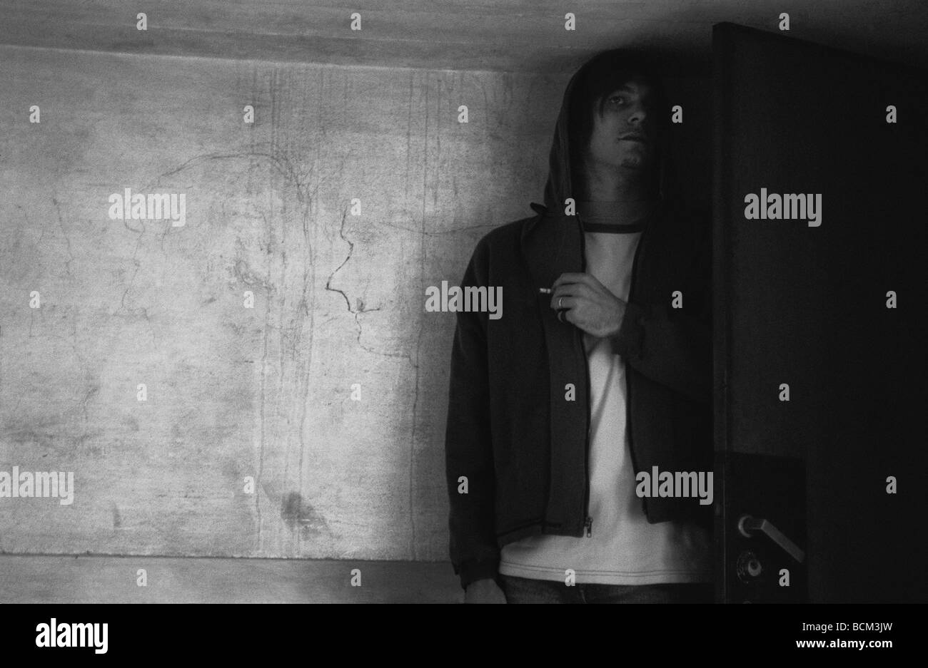 Man hiding behind door Stock Photo