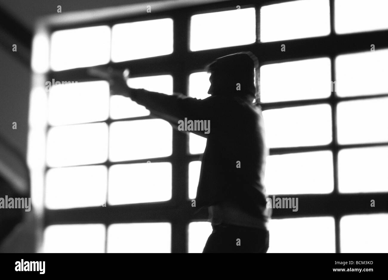 Dark silhouette of person pointing gun Stock Photo