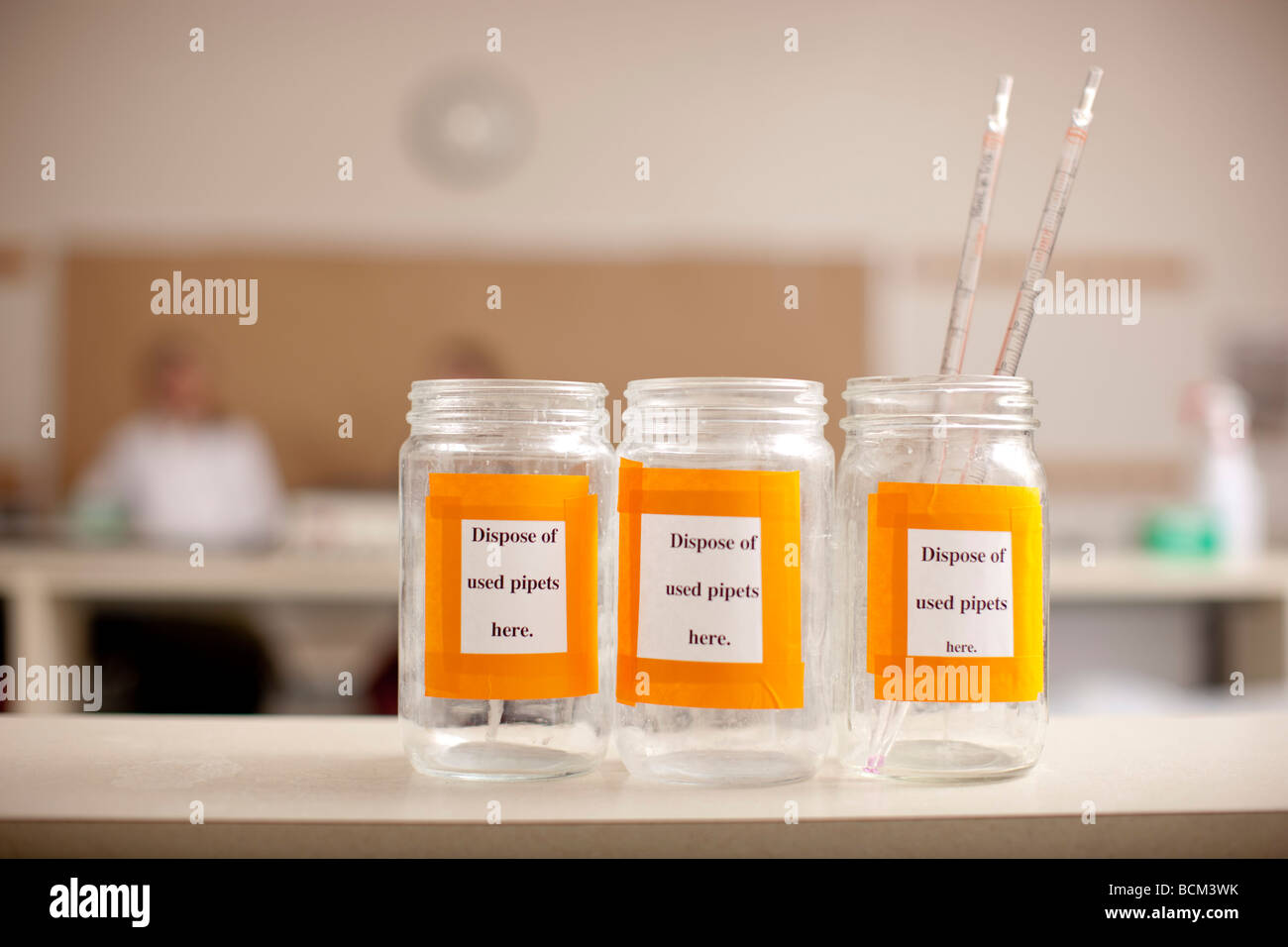 Glass bottles in classroom lab for disposal of Pipets Stock Photo
