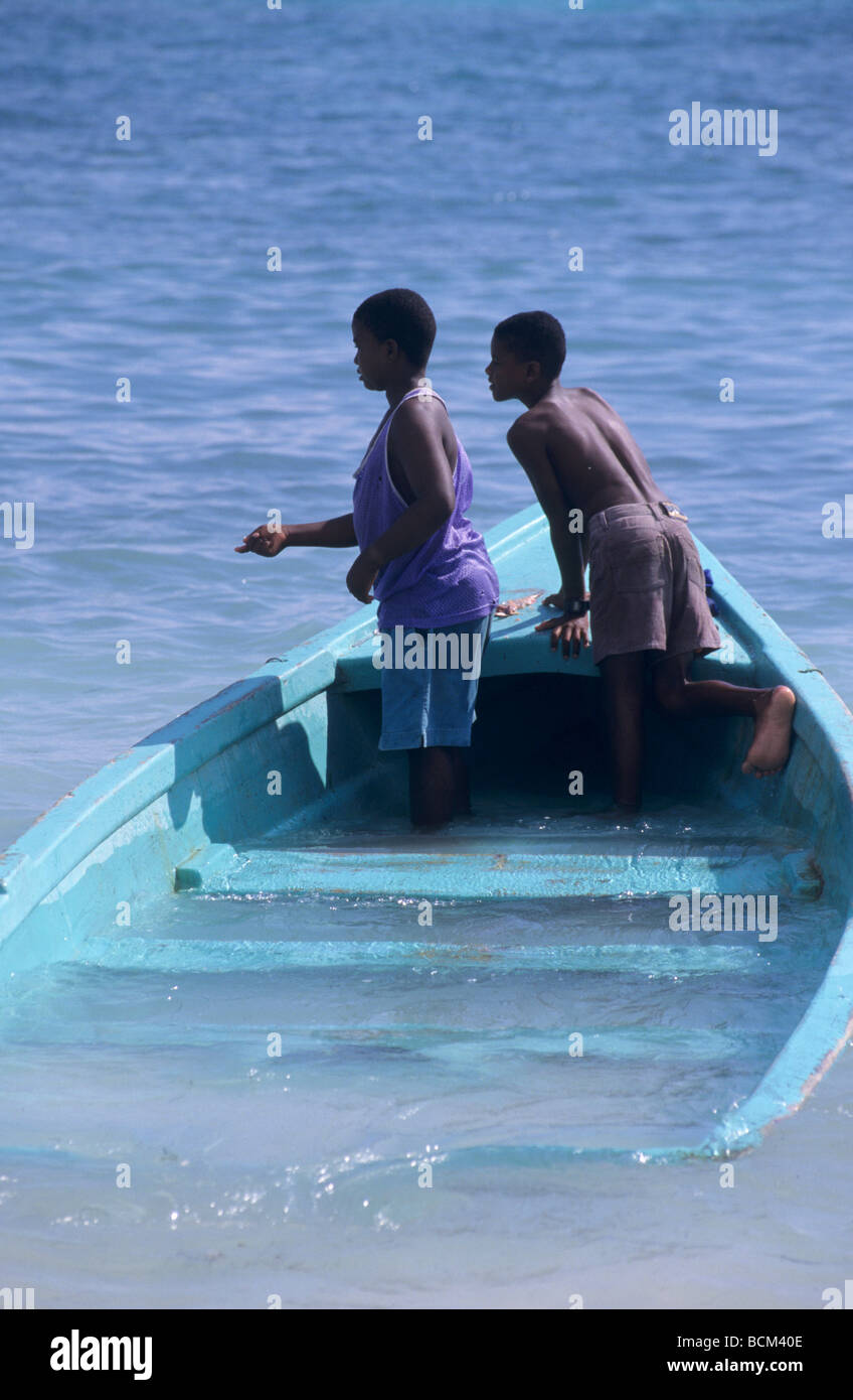 Two kids fishing a sinking boat. Saona island, Dominican Republic