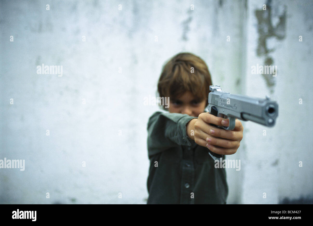 Boy pointing gun Stock Photo