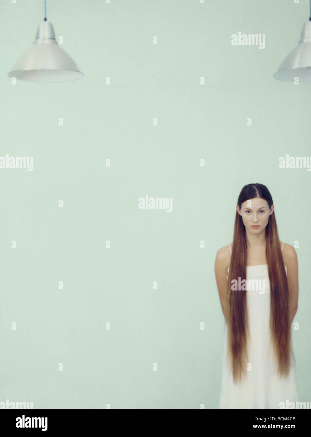 Young woman with long hair standing, looking at camera Stock Photo