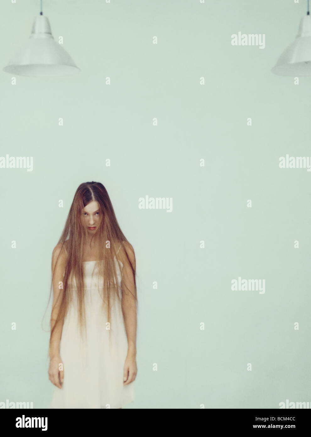 Young woman with messy long hair standing, looking at camera Stock Photo