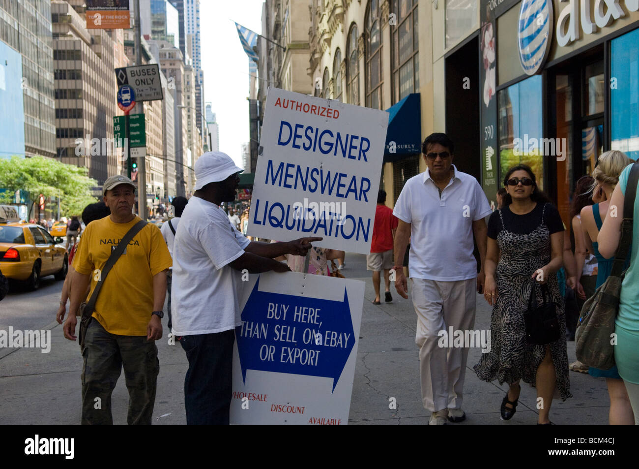 A worker holds up a sign advertising a mens ware liquidation sale in midtown in New York Stock Photo