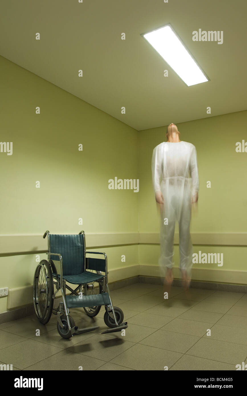Man floating in mid-air near wheelchair, blurred Stock Photo