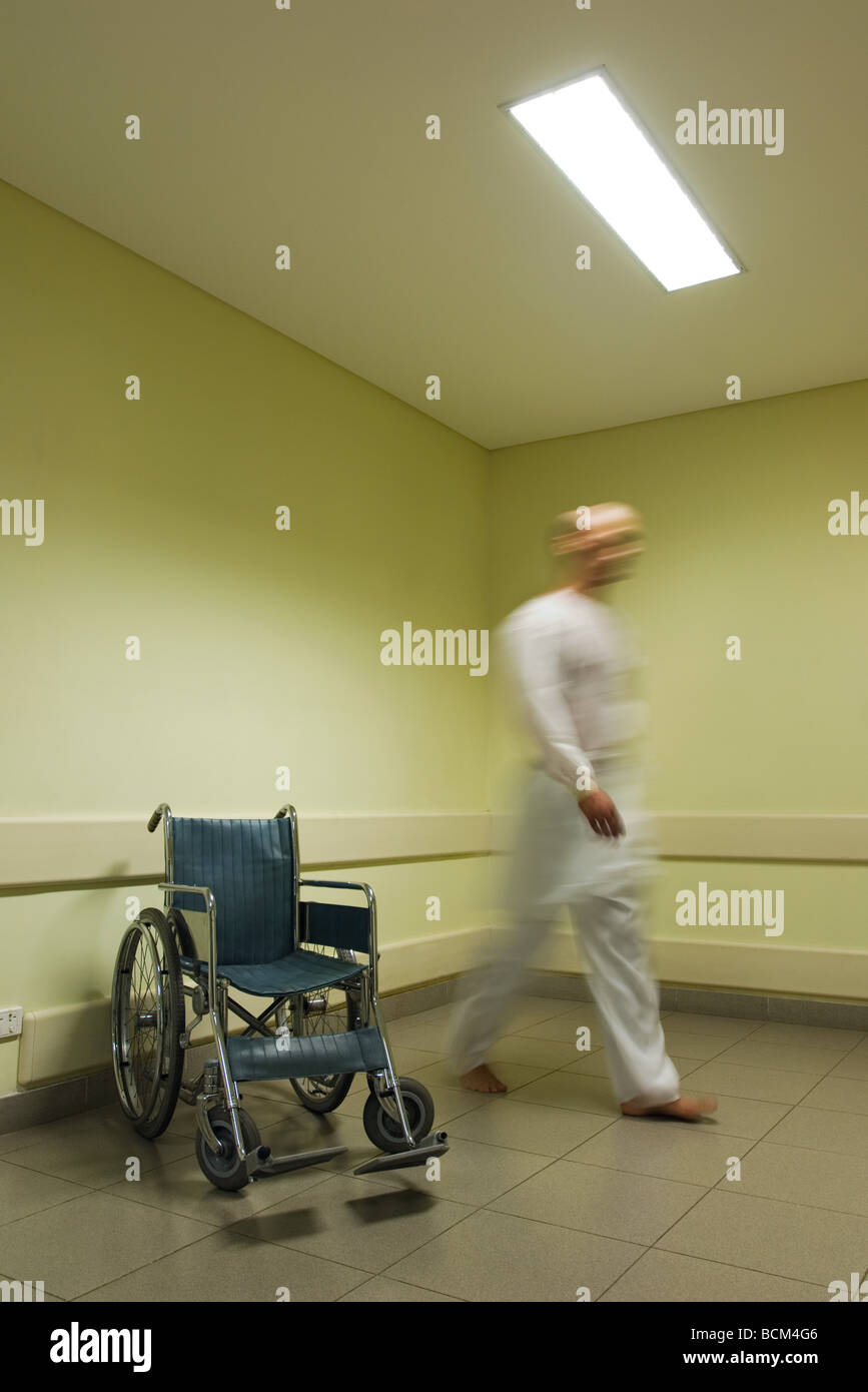 Man walking away, near wheelchair, blurred motion Stock Photo