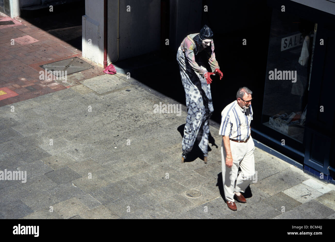 Street Busker on Stilts About to Frighten a Man Walking on the Footpath Perth Western Australia Stock Photo