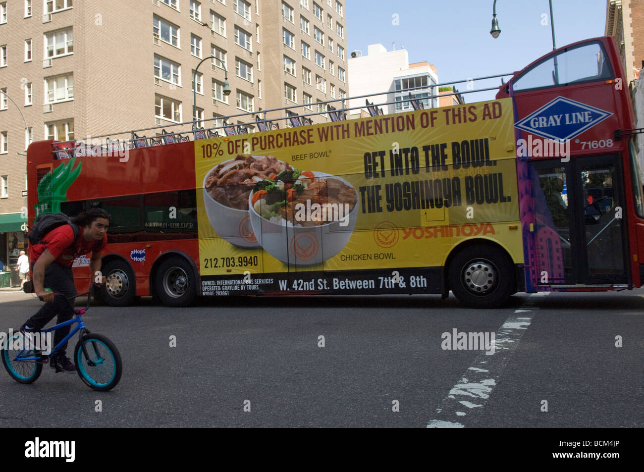 A Gray Line double decker sightseeing bus advertises the Japanese restaurant Yoshinoya located in Times Square in New York Stock Photo